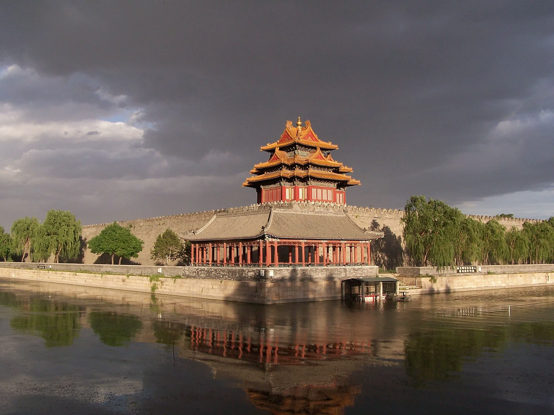 Forbidden City corner tower reflected in the moat at sunset