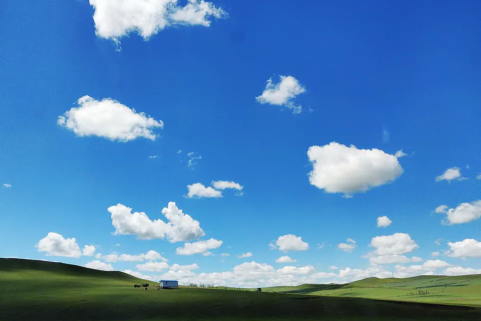 Rolling green Hulun Buir grassland beneath a deep blue sky in Inner Mongolia
