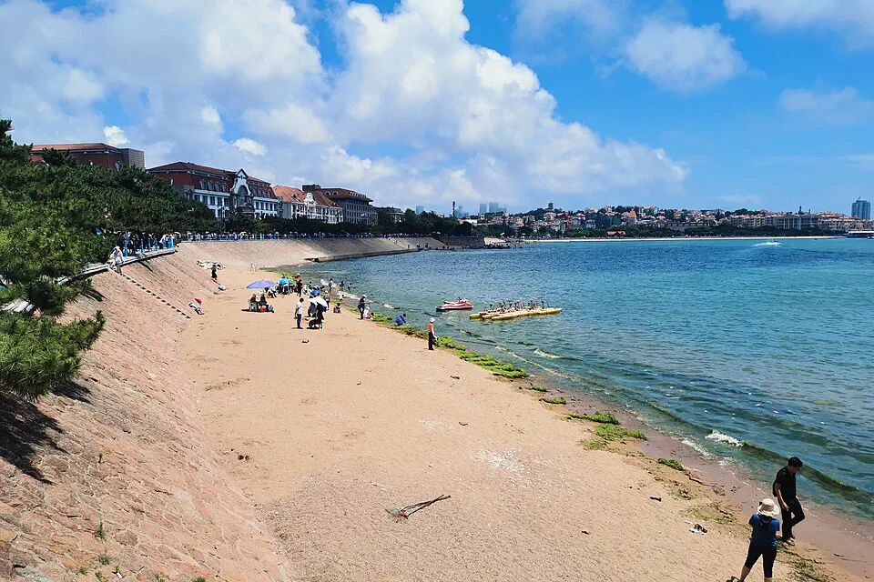 Sandy waterfront and red-roofed historic buildings beside the sea in Qingdao