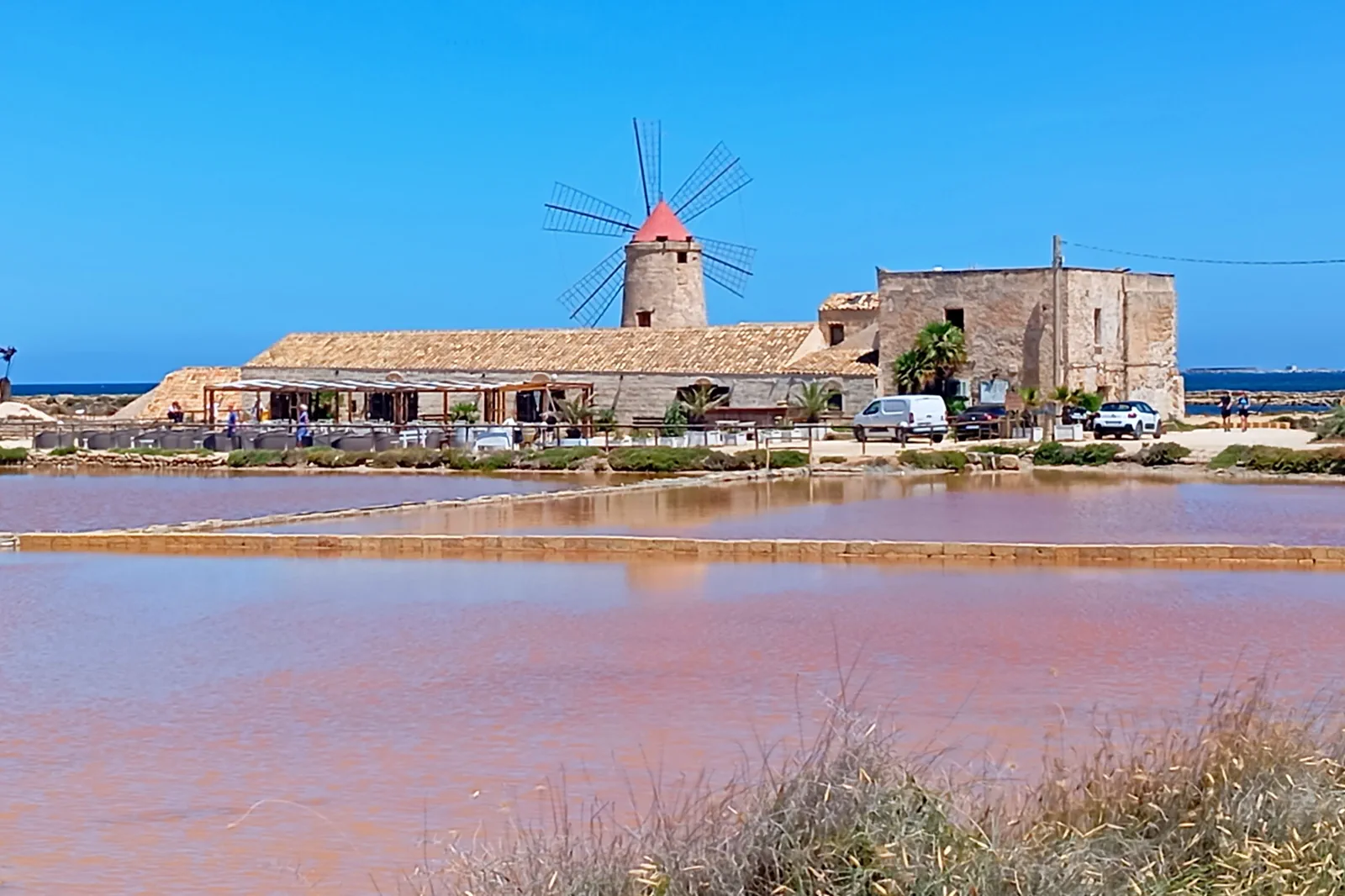 Salt pans and windmills glowing at sunset near Trapani