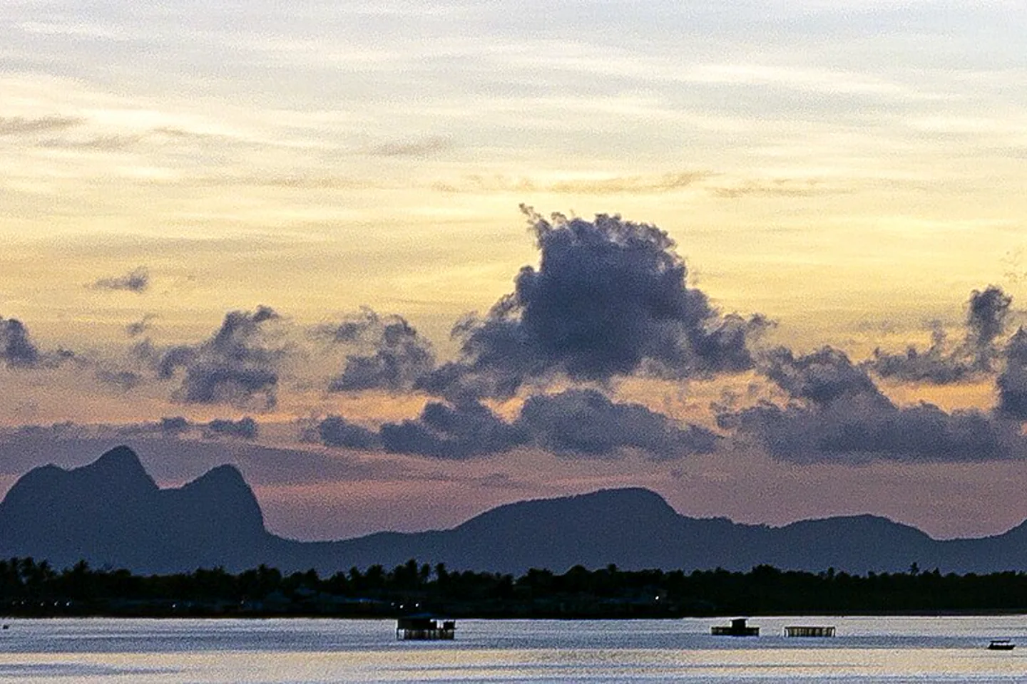 Tun Sakaran island silhouettes across calm water at sunset