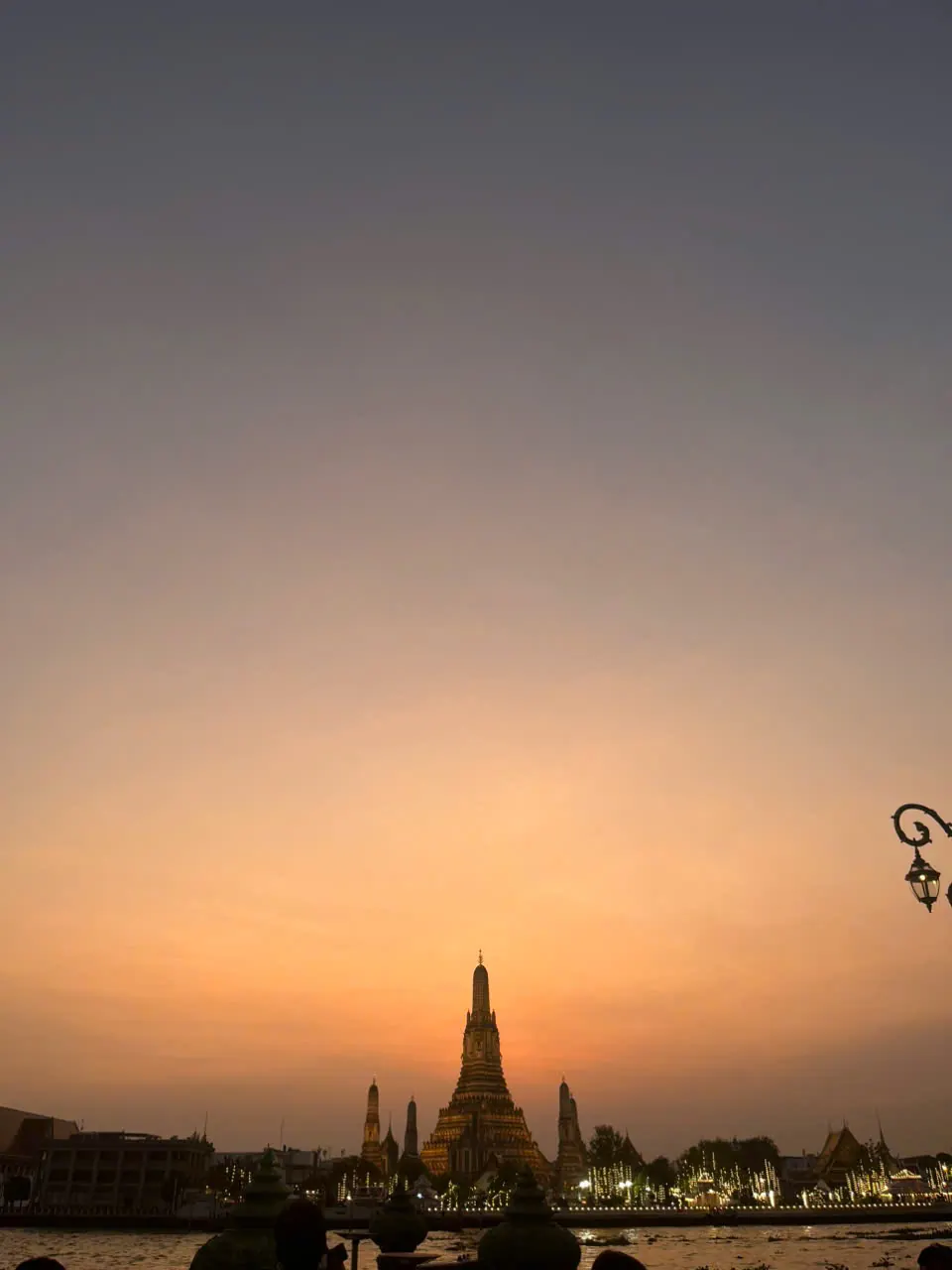 Wat Arun silhouetted in warm Bangkok sunset light