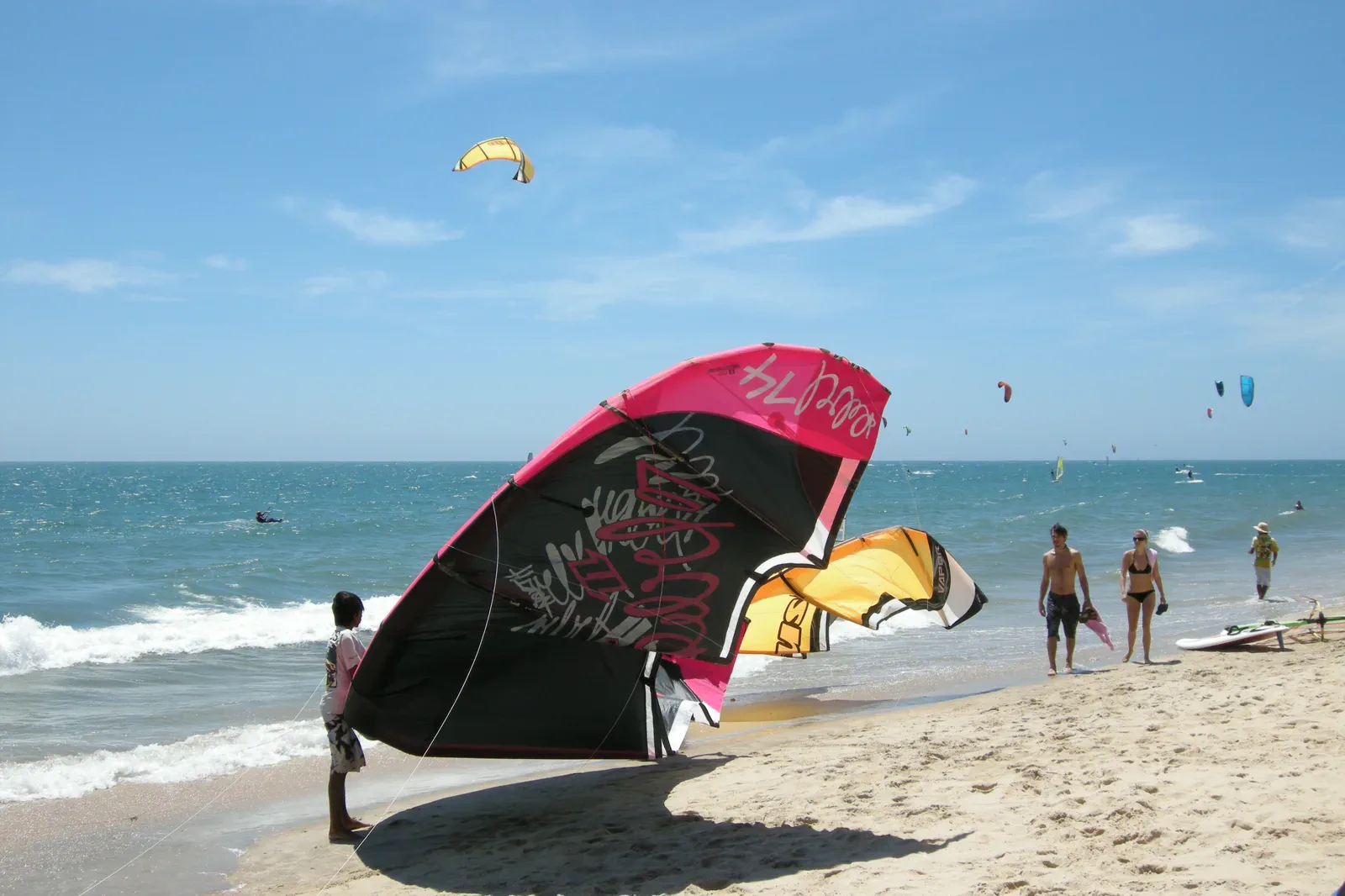 Kitesurfers flying colorful kites above Mui Ne beach